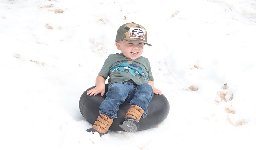 小男孩从雪山上滑下来