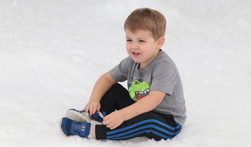 小男孩坐在雪地上
